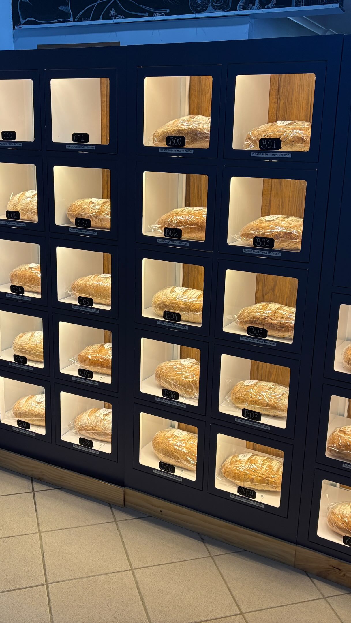 Fresh packaged bread displayed inside the Bread Wall collection compartments