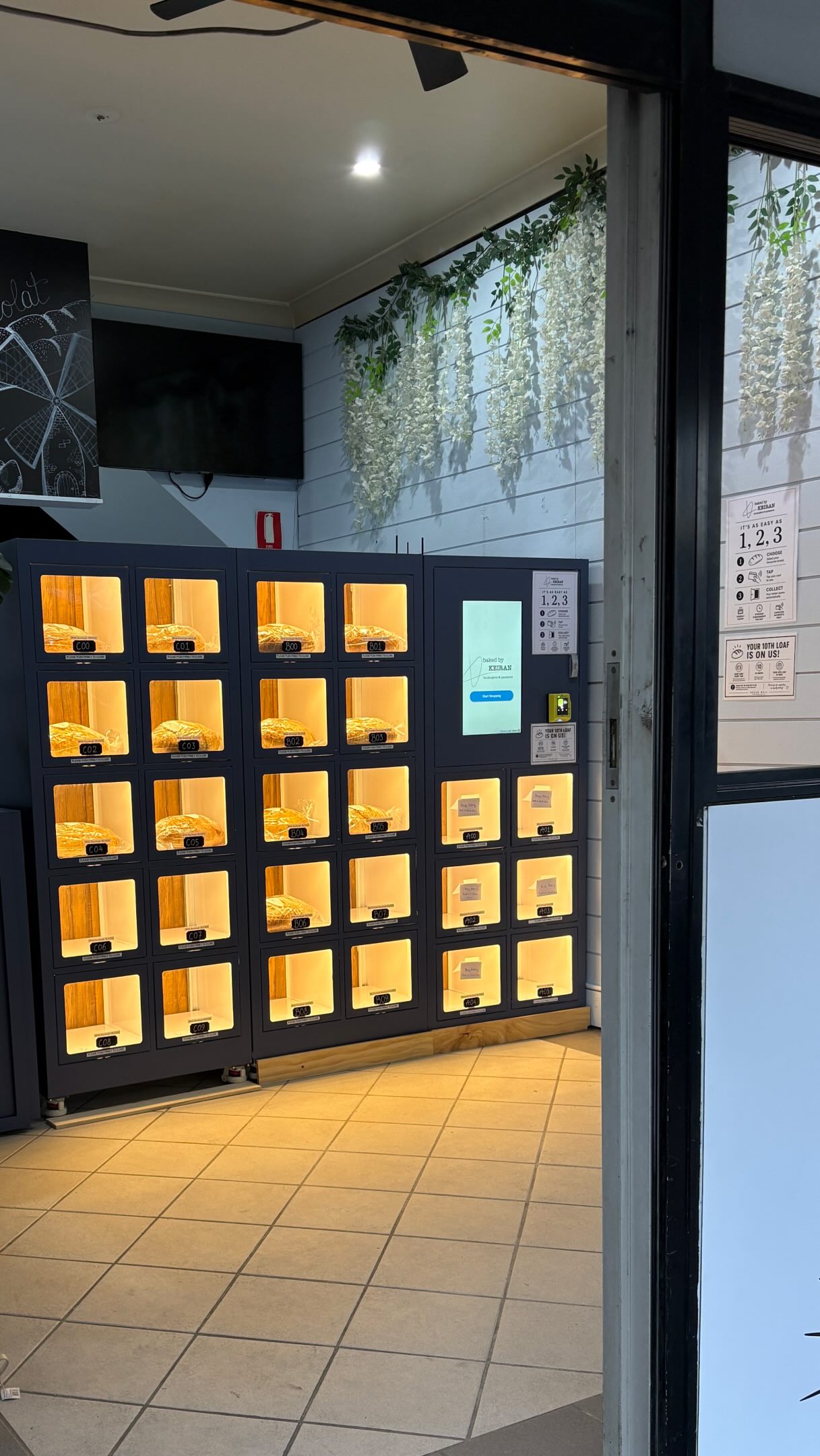 Baked by Keiran Bread Wall with touchscreen kiosk and illuminated bread compartments